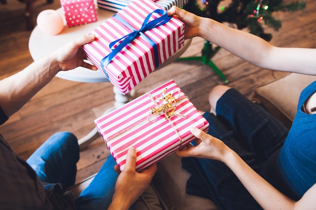 Pareja dando regalos el uno al otro.