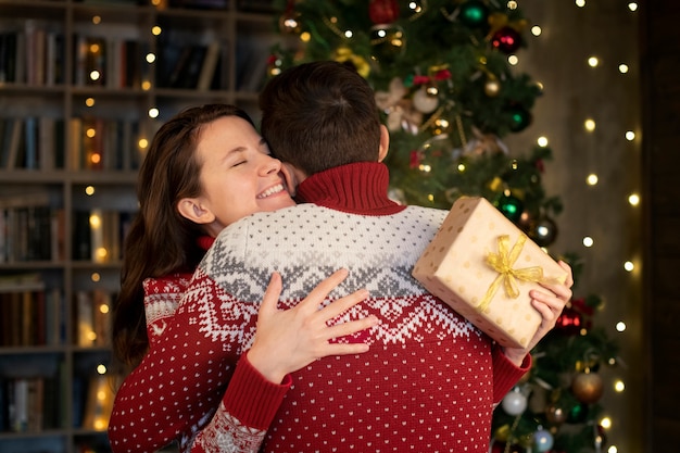 Foto pareja dándose regalos de navidad