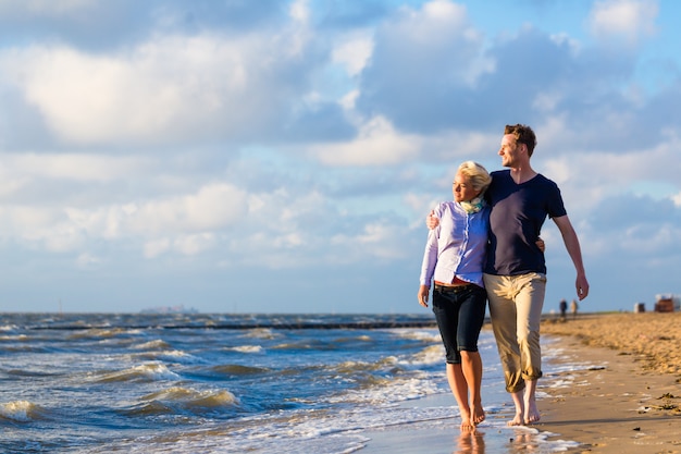 Pareja dar un paseo en la playa alemana del mar del norte