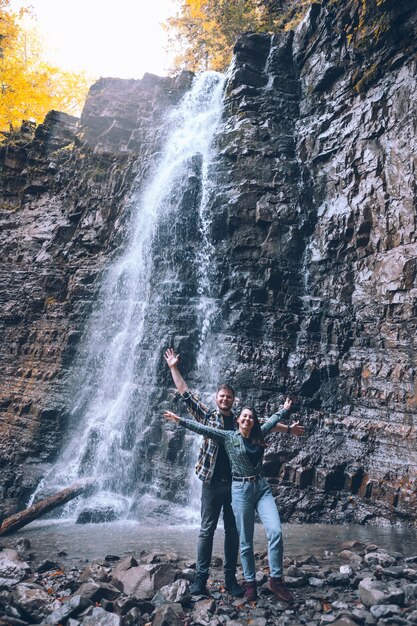 Pareja delante del espacio de copia de la temporada de otoño de cascada