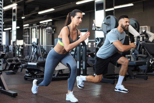 Pareja de deporte atractivo haciendo fitness en el gimnasio.