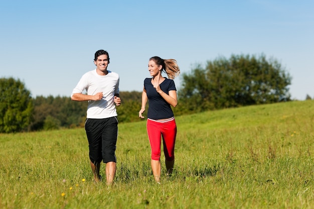 Foto pareja deporte trotar en pradera