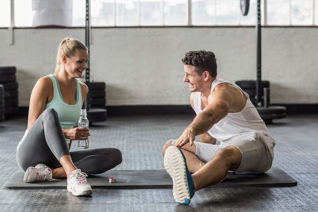 Pareja de deportes tomando descanso y hablando juntos