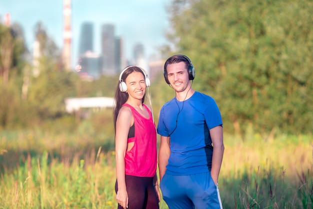 Pareja deportiva activa corriendo en el parque.