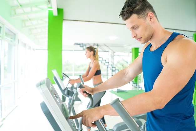 La pareja deportiva en el aparato de cardio