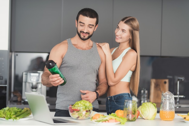 Pareja Deportiva En La Cocina. Cóctel De Verduras.