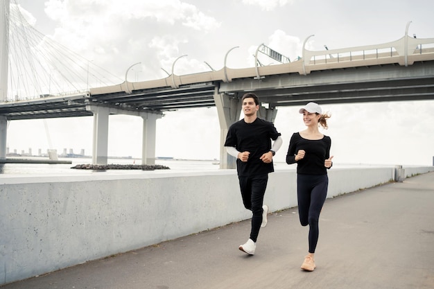 Una pareja deportiva corriendo por la calle entrenamiento físico corriendo en zapatillas de deporte Usan un gimnasio