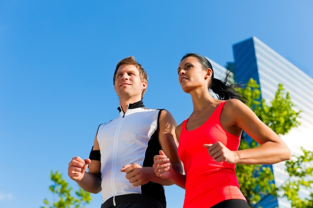 Pareja deportiva corriendo en la ciudad