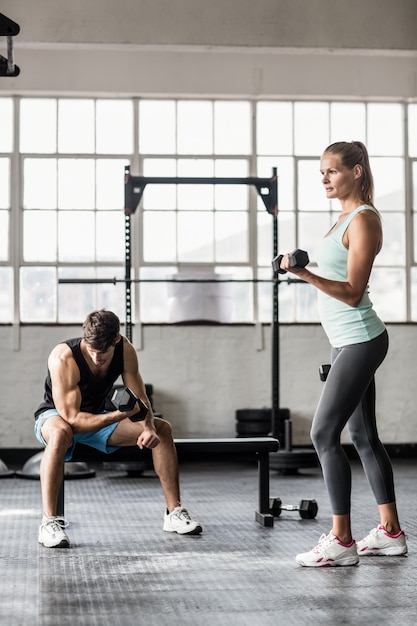 Pareja deportiva haciendo ejercicio con pesas