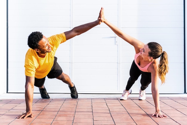 Pareja deportiva multiétnica entrenando al aire libre