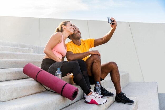 Pareja deportiva multiétnica entrenando al aire libre