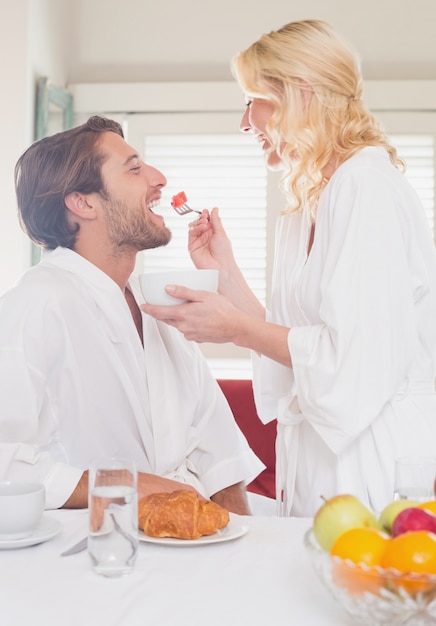 Pareja desayunando en sus albornoces