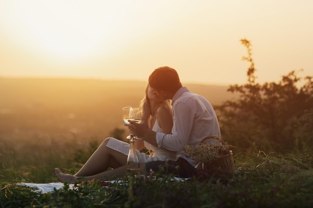 la pareja descansa juntos en un picnic al aire libre al atardecer