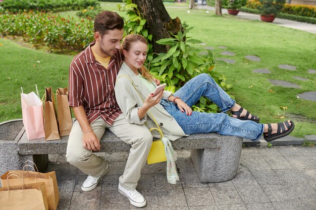 Pareja descansando al aire libre después de comprar