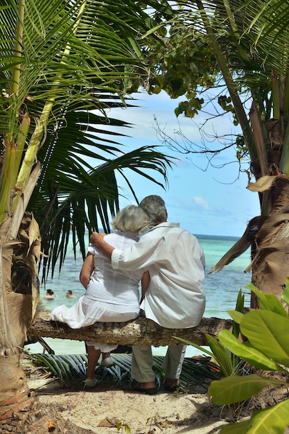 Pareja descansando en la playa tropical