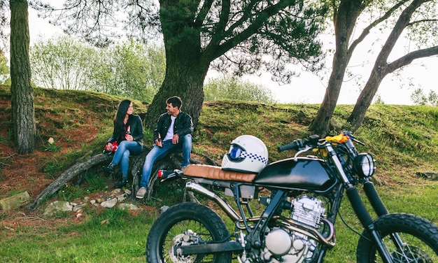 Pareja descansando de un viaje en moto