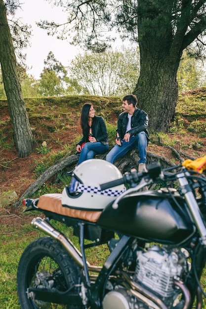 Pareja descansando de un viaje en moto