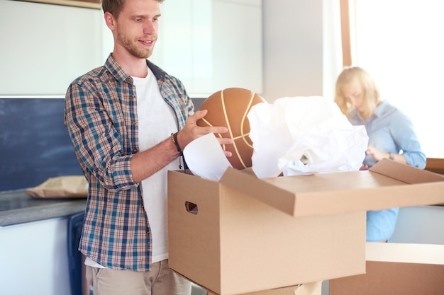 Pareja desempacando cajas de cartón en su nuevo hogar pareja joven