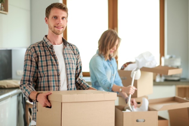 Pareja desempacando cajas de cartón en su nuevo hogar pareja joven