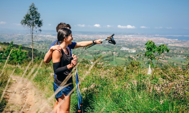 Pareja deteniéndose para mirar las vistas mientras hace un sendero