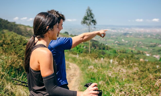 Pareja deteniéndose para mirar las vistas mientras hace un sendero