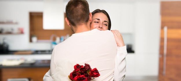 Pareja en el día de San Valentín con flores en una casa