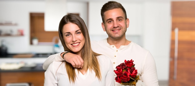 Pareja en el día de San Valentín con flores y regalos en una casa