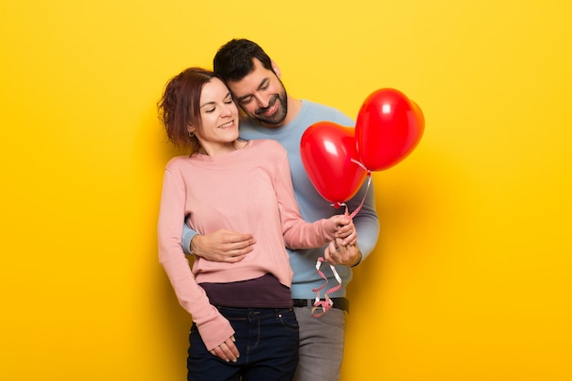 Pareja en el día de San Valentín con globos con forma de corazón