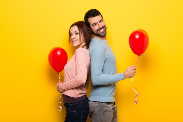 Pareja en el día de San Valentín con globos con forma de corazón