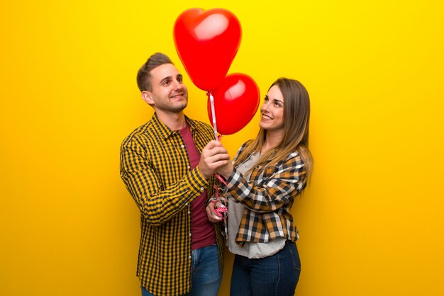 Pareja en el día de San Valentín con globos con forma de corazón