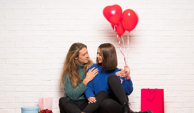 Pareja en el día de San Valentín con globos con forma de corazón