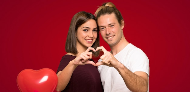 Pareja en el día de San Valentín haciendo un corazón con las manos