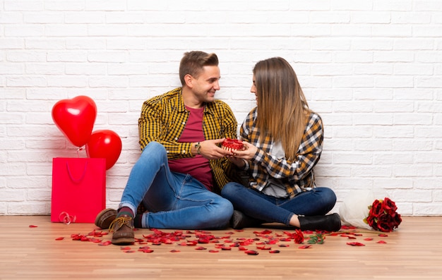 Pareja en el día de San Valentín en el interior con caja de regalo