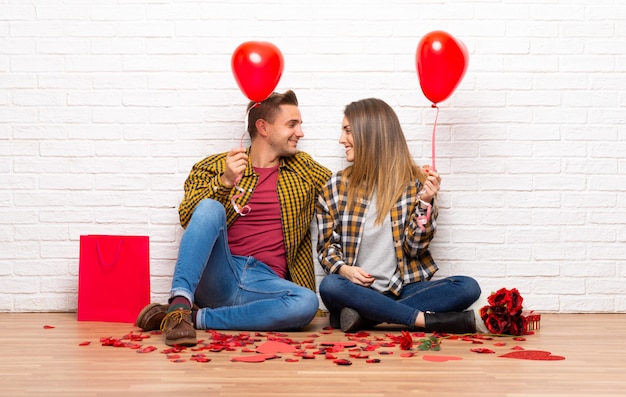 Foto pareja en el día de san valentín en el interior con globos con forma de corazón