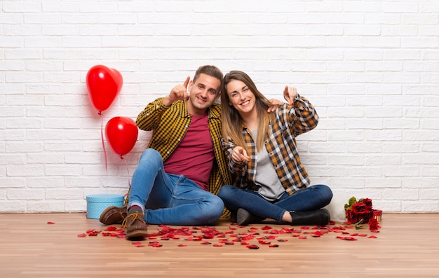 Pareja en el día de San Valentín en el interior señala con el dedo a usted con una expresión de confianza