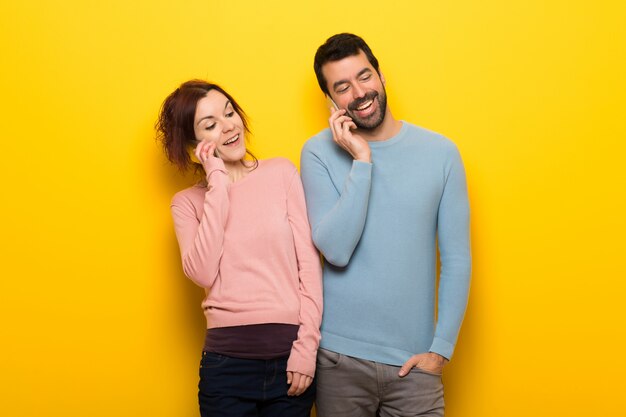 Pareja en el día de San Valentín manteniendo una conversación con el teléfono móvil