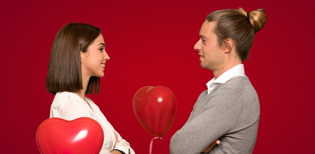 Pareja en el día de San Valentín en posición lateral sobre fondo rojo