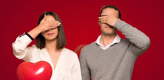 Pareja en el día de san valentín que cubre los ojos con las manos. No quiero ver algo