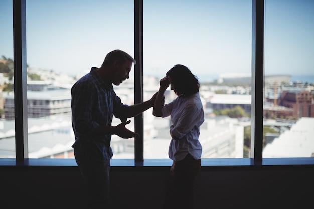 Pareja discutiendo cerca de la ventana