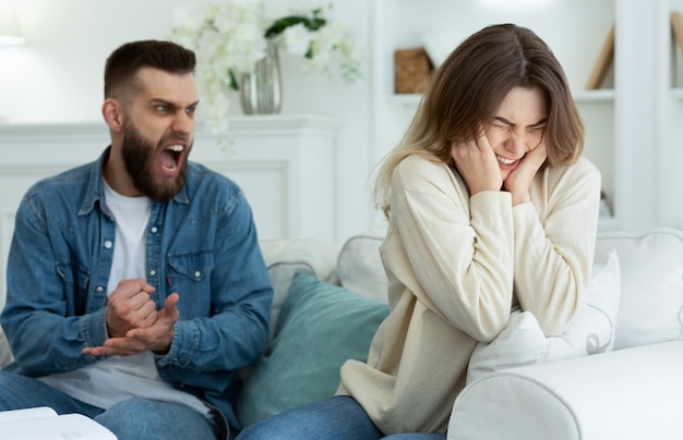 Pareja discutiendo marido gritando a esposa desesperada