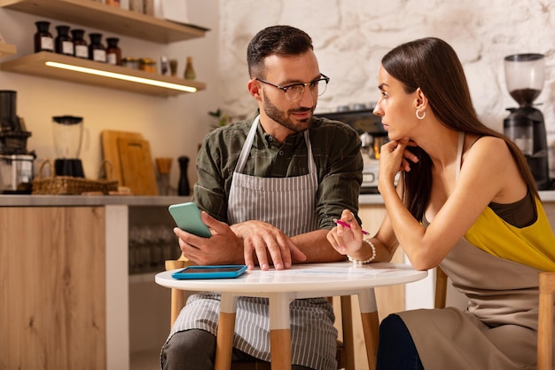 Foto pareja discutiendo mientras abre su propia cafetería