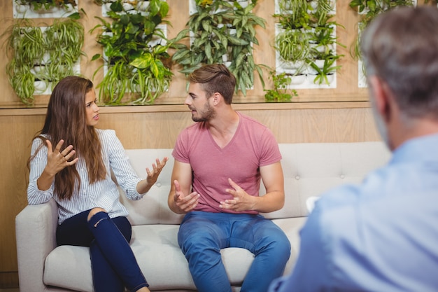 Pareja discutiendo en sesión de asesoramiento con un médico