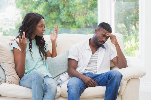 Pareja discutiendo en el sofá