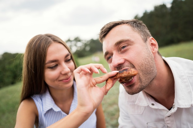 Pareja disfrutando de la comida en una barbacoa