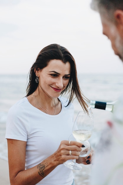 Pareja disfrutando de una copa de vino en la playa