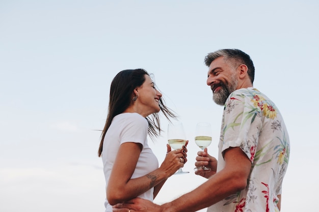 Pareja disfrutando de una copa de vino en la playa