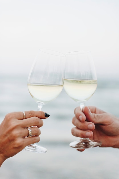 Pareja disfrutando de una copa de vino en la playa.