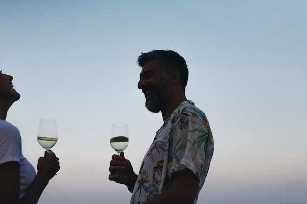 Pareja disfrutando de una copa de vino en la playa.