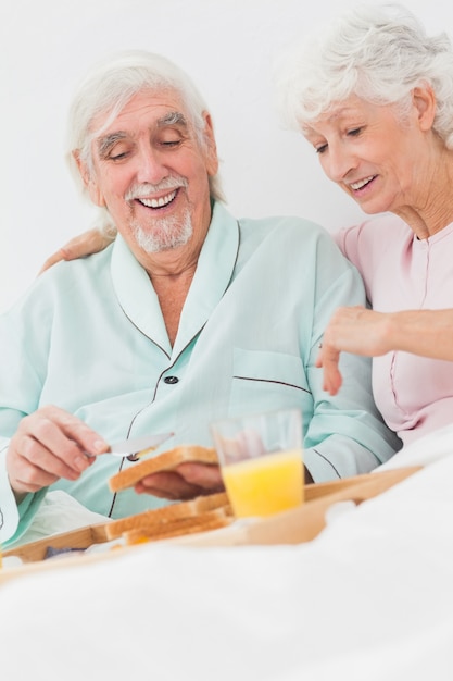 Pareja disfrutando de un desayuno en la cama