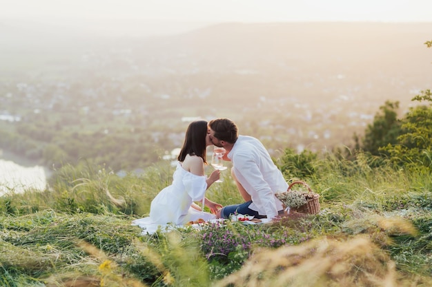 pareja disfrutando de un romántico picnic en el campo y besándose